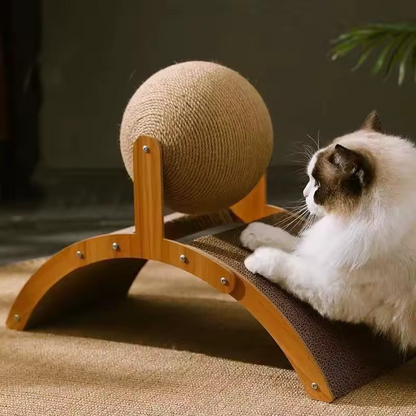 Fluffy cat pawing at spinning sisal ball on curved cardboard scratcher